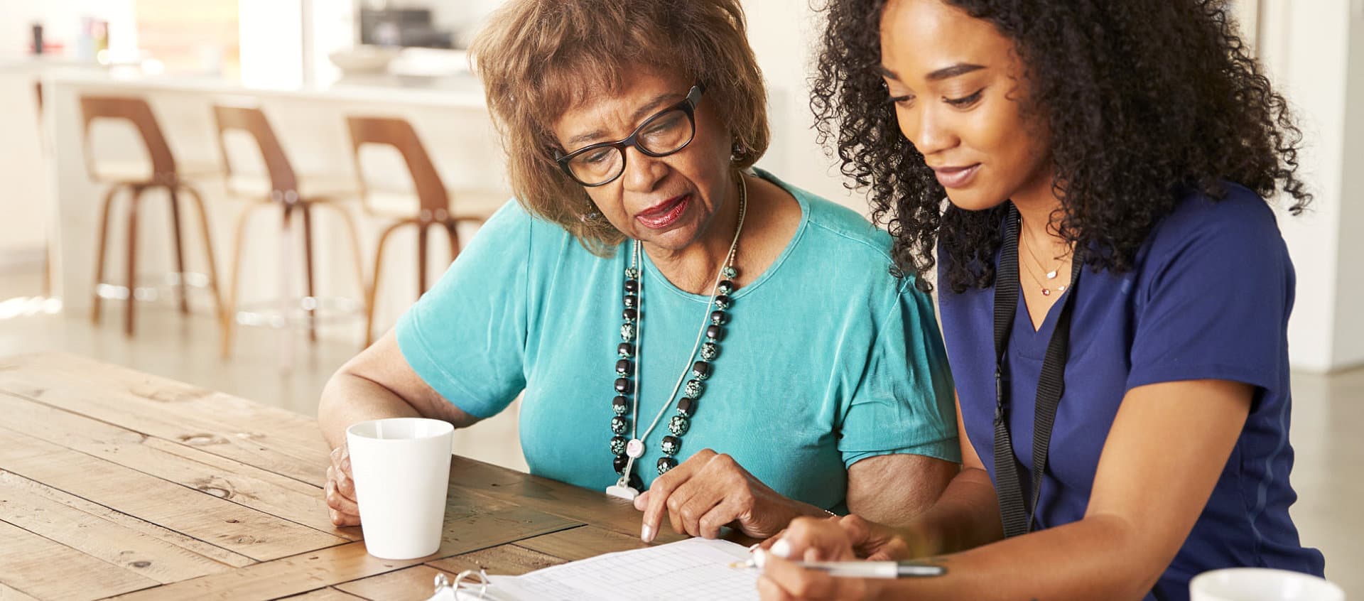 caregiver reading a document for a senior woman